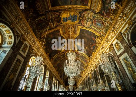 Iconic Ceiling Frescoes and Chandeliers in the Hall of Mirrors of Versailles Palace - Versailles, France Stock Photo