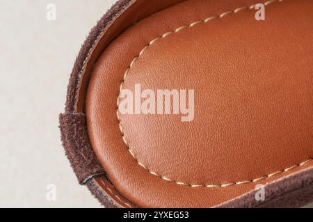 close-up of reddish brown women leather sandals with natural grain and texture and stitching line around the edge, craftsmanship of leather product Stock Photo