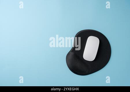 Top view of modern white mouse on black mousepad on blue table Stock Photo