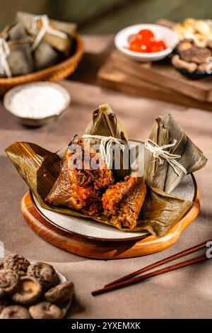 Zongzi is a traditional Chinese food made of glutinous rice stuffed with different fillings and wrapped in bamboo reed, or other large flat leaves. Th Stock Photo