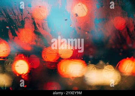 Traffic lights on rainy night, bokeh background with selective focus Stock Photo