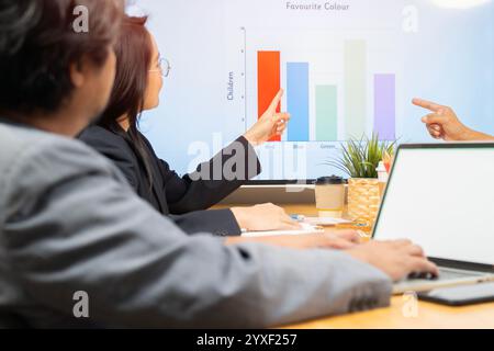 Diverse corporate team working together in modern meeting room office. Back view, selective focus. Stock Photo