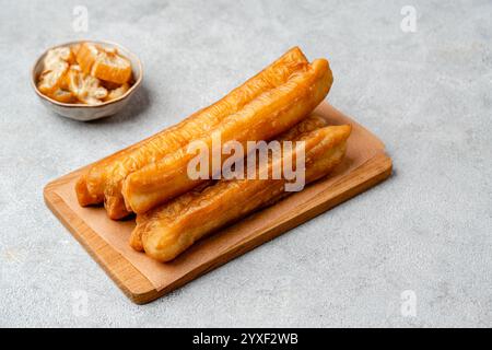 Youtiao or Yu Char Kway is a long golden brown deep-fried strip of wheat flour dough of Chinese origin Stock Photo