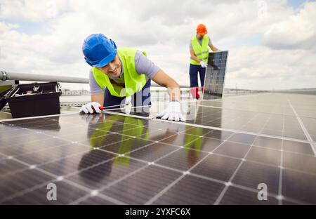 Team of workers electrical engineers in uniform installing photovoltaic solar panels Stock Photo