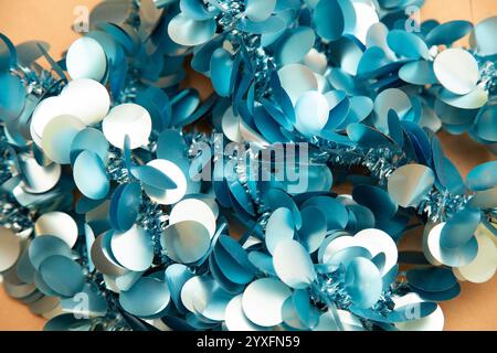 There is a cluster of blue and white sequins scattered on a table Stock Photo