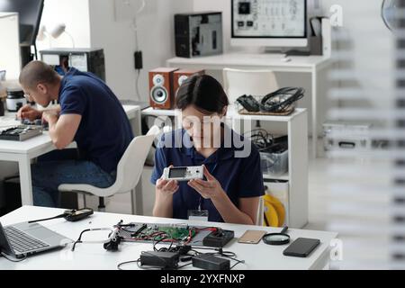 Analyzing Electronic Devices in Tech Laboratory Setting Stock Photo