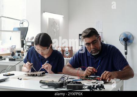 Collaborative Engineers Working on Circuit Boards in Lab Stock Photo