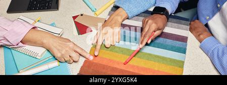 Website header shot of diverse team of designers choosing fabric among various color samples on tabletop while working together on new project in office, copy space Stock Photo