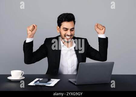 Businessman celebrating a success while working in a modern studio setting Stock Photo