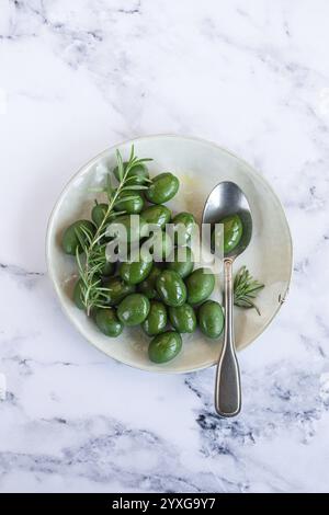 Chalkidiki olives, classic Greek green olive, on a plate, with a spoon, top view, no people Stock Photo