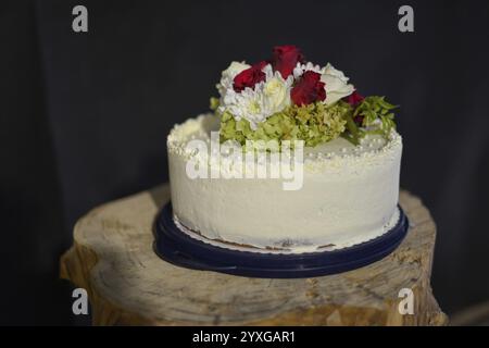 White wedding cake with roses and flower decorations on a wooden block, Bavaria, Germany, Europe Stock Photo