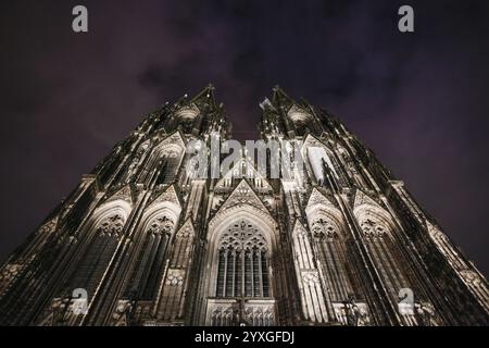 Cologne Cathedral, an impressive Gothic cathedral, illuminated at night and photographed against the cloudy sky, Cologne, North Rhine-Westphalia, Germ Stock Photo