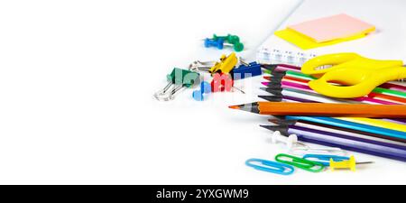 A collection of vibrant school supplies including pencils, scissors, paper clips, and notepads arranged on a white background, perfect for illustratin Stock Photo