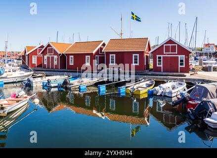 Typical red huts in the guest harbour of Skärhamn, Sweden, a popular marina in the tourist province of Bohuslän, surrounded by moored boats. Stock Photo