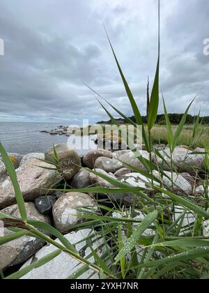 Dramatic coastline with big stones in the foreground and the ocean and cloudy skies in the backgrund. Picture taken in Skåne, Sweden in August 2023. Stock Photo