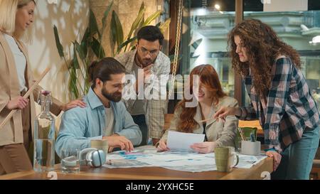 Multiracial multiethnic group coworking office team business women men girls guys male female students coworkers architects paperwork discussion Stock Photo