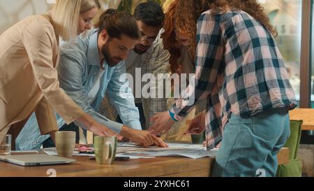 Office team multi ethnic designers male female group coworkers architects engineers constructors business men women discussing building plan Stock Photo