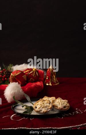 A verical table setting with space for editorial above a table setting with red velvet, minced pies on a plate with mistletoe and Christmas trimmings Stock Photo