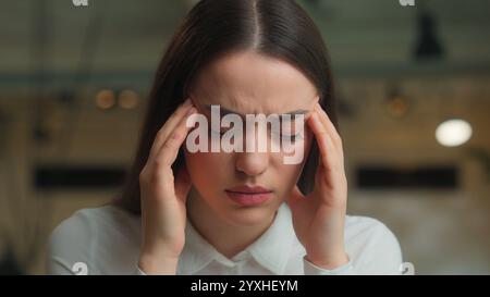 Caucasian businesswoman business woman female lady office worker student studying online work laptop feel headache suffer migraine health problem Stock Photo