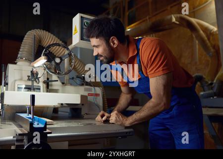 Woodworker using planer machine for production wooden materials specific size Stock Photo