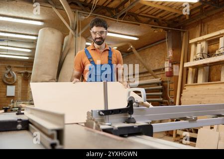 Male artisan worker holding and assembling pieces of wood using glue Stock Photo