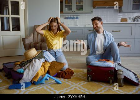 Funny couple packing clothes for travel vacation at home Stock Photo