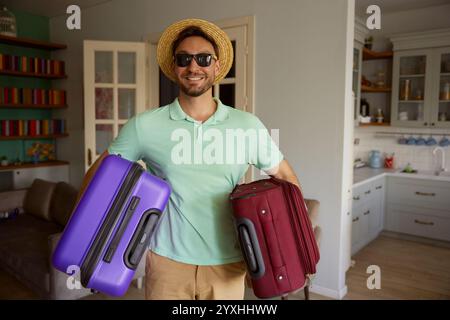 Portrait of happy man tourist carrying packed luggage suitcases Stock Photo