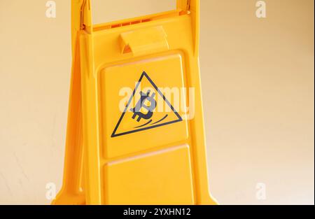 Bitcoin symbol icon slipping falling over warning sign crypto rug pull concept, bear market prices fall symbol cryptocurrency market risk, price volat Stock Photo