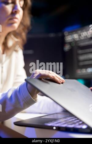 Cybersecurity expert using laptop to look for company security vulnerabilities and injected malware. Programmer installing fortified code on notebook device to prevent cyber attacks Stock Photo