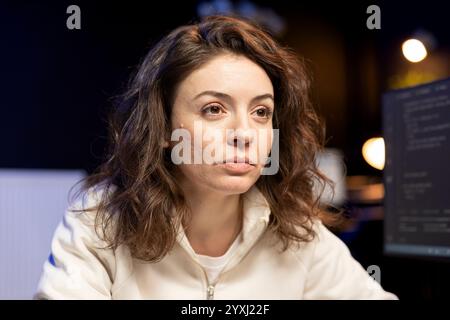 Computer engineer focused on doing software quality assurance, reading source code on screen before implementing it. Technician inspecting coding on desktop PC, looking to fix potential issues Stock Photo