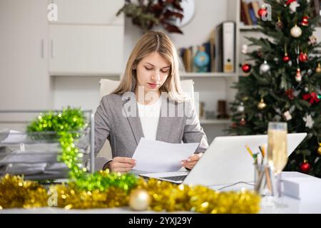 Woman working with documents during Christmas Stock Photo