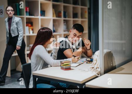 Students studying together in a library with books and pencils Stock Photo
