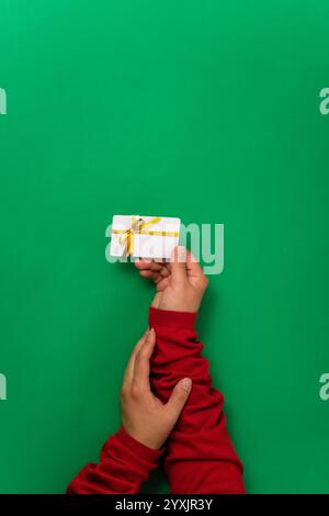 Holiday-themed concept with woman hands showcasing a gift or shopping card. Minimalistic design with woman hands holding a plastic card for Christmas Stock Photo