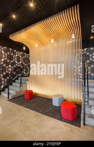 Angle view of entrance lobby to new apartment building with unique laser cut wood “wave wall” Stock Photo