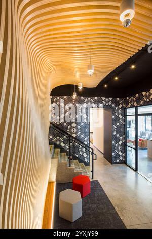 View of curving wood wall in entrance lobby to new apartment building Stock Photo