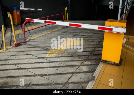 A barrier and access verification panel at the exit of an underground private carpark Stock Photo