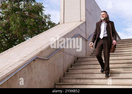 stylish businessman in suit on urban stairs Stock Photo