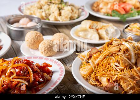 A view of several Chinese entrees and dumpling appetizers on a table. Stock Photo
