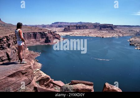 Hiker looking at Lake Powell on Colorado River, high water level in 1980, view from Hite Overlook, near Hite Marina (now closed), Glen Canyon National Recreation Area, Colorado Plateau, Utah, USA Stock Photo