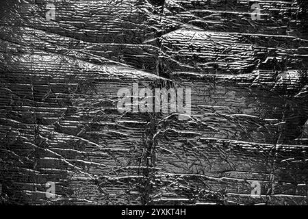 Crumpled soft packaging foil with wrinkles and folds. Shiny textured surface. Abstract metallic background. Close-up Stock Photo