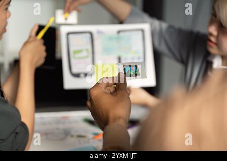 Creative UX UI Design Team Collaborating on Innovative Mobile App Interface with Wireframes and Prototypes Stock Photo