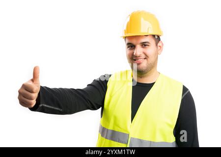 Adult constructor man wearing yellow vest and hardhat for safety smiling showing like gesture with thumb-up isolated on white background Stock Photo