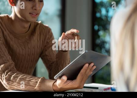 Modern UX UI Designer Working on Tablet in Bright Office Environment for Innovative Digital Solutions Stock Photo