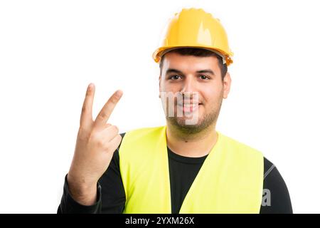 Builder man wearing safety hardhat and fluorescent vest work equipment showing number two or second using fingers as counting concept smiling friendly Stock Photo