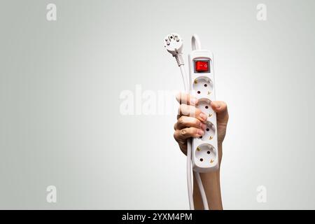Hand holding a European power strip with extension cord Stock Photo