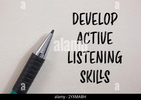 Develop active listening skills message written on black paper with red ...