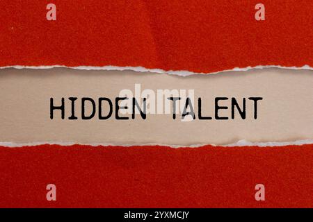 Hidden talent message written on ripped torn red paper with beige background. Conceptual hidden talent symbol. Copy space. Stock Photo