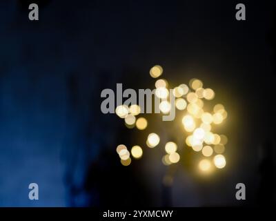 semi-abstract pattern of defocussed golden lights against a dark blue background Stock Photo