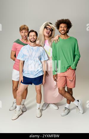 Four joyful individuals express their pride in colorful outfits while posing together. Stock Photo
