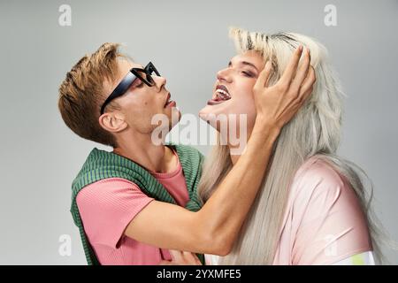 Two individuals express joy and affection in a colorful atmosphere, celebrating pride. Stock Photo